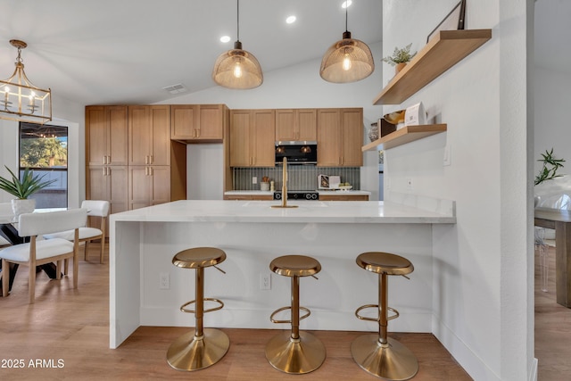 1001 N Nielson St, Gilbert, AZ 85234 - kitchen featuring stainless steel microwave, backsplash, open shelves, decorative light fixtures, and light wood-style flooring