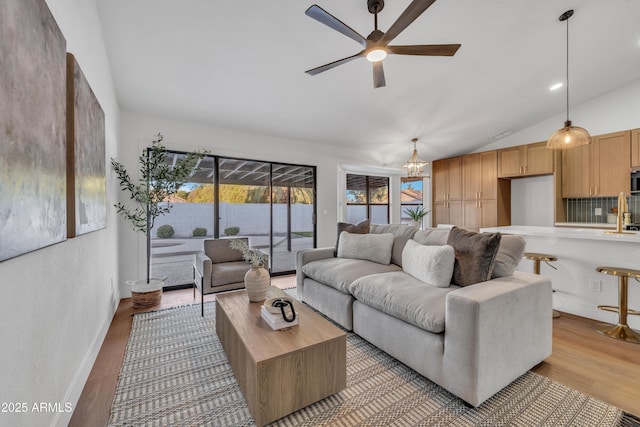 1001 N Nielson St, Gilbert, AZ 85234 - living room featuring ceiling fan, light wood-type flooring, vaulted ceiling, a chandelier, and baseboards