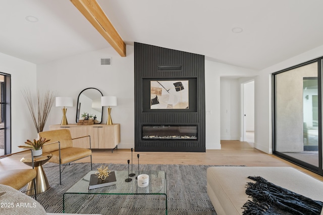 living room with vaulted ceiling with beams and light hardwood / wood-style flooring