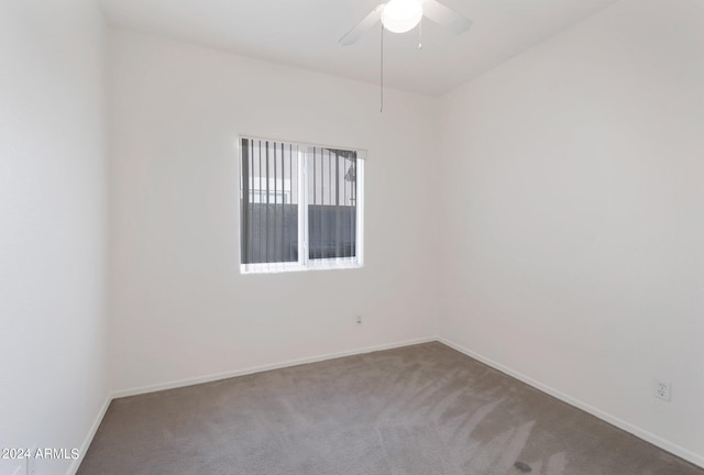 carpeted spare room with ceiling fan