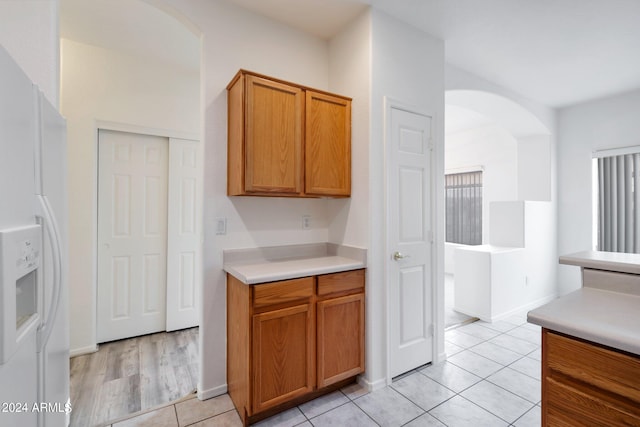 kitchen with white fridge with ice dispenser and light tile patterned floors