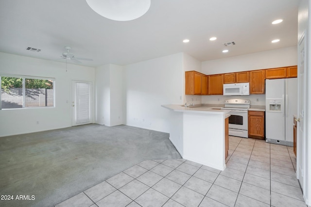 kitchen featuring white appliances, ceiling fan, kitchen peninsula, and light carpet