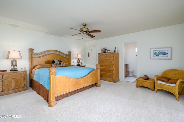 bedroom featuring light colored carpet, ceiling fan, and connected bathroom