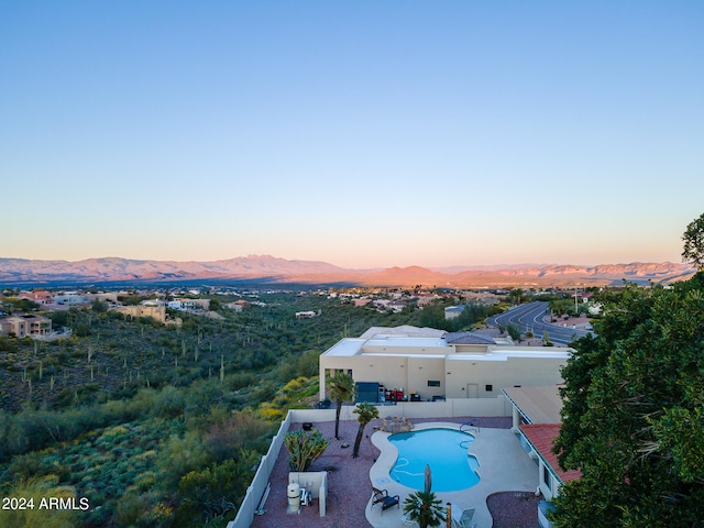 pool at dusk featuring a patio