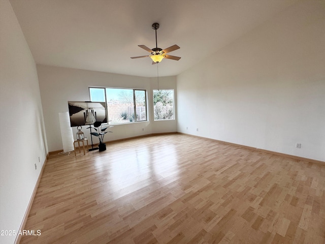 unfurnished room with light wood finished floors, baseboards, vaulted ceiling, and a ceiling fan