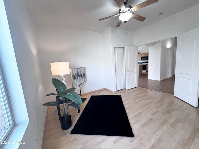 workout room featuring ceiling fan, wood finished floors, and baseboards