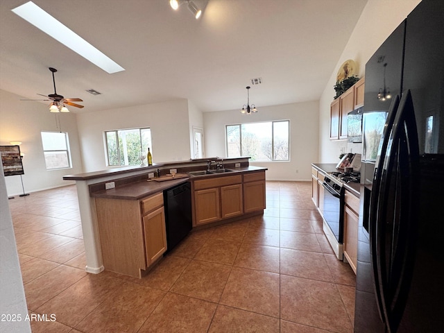 kitchen with dark countertops, plenty of natural light, black appliances, and light tile patterned floors