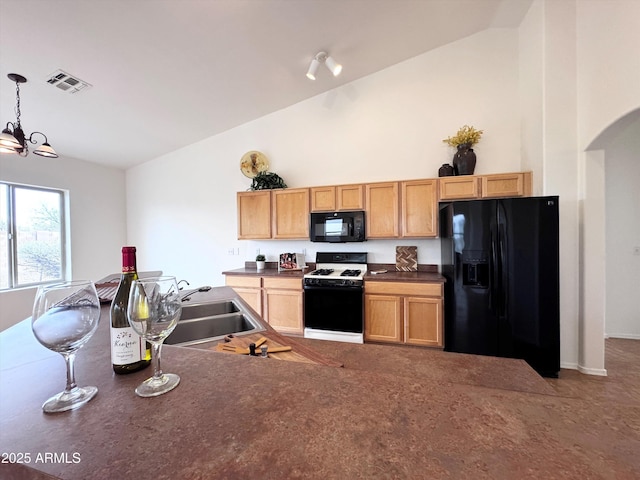 kitchen featuring visible vents, dark countertops, black appliances, pendant lighting, and a sink