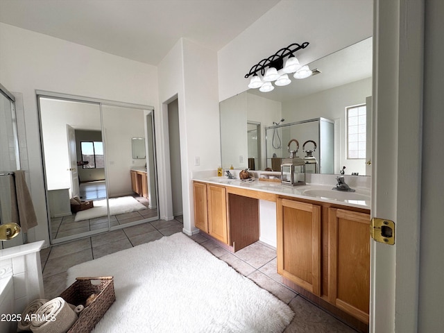 full bathroom featuring double vanity, a stall shower, tile patterned flooring, and a sink