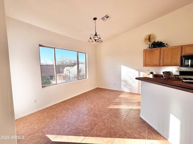 kitchen featuring black microwave, lofted ceiling, visible vents, dark countertops, and range with gas cooktop