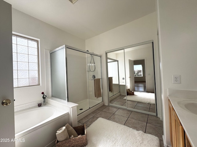 bathroom featuring a stall shower, tile patterned flooring, a garden tub, and vanity