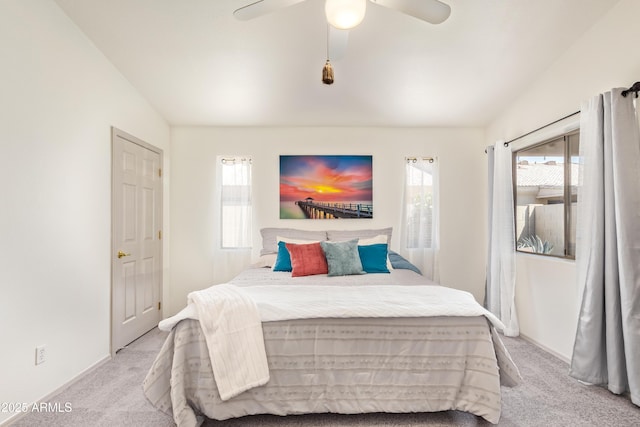 bedroom featuring light colored carpet, ceiling fan, baseboards, and lofted ceiling