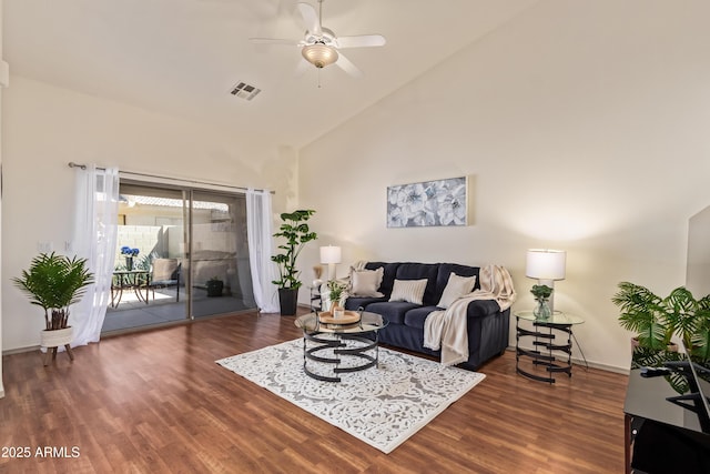 living room featuring ceiling fan, wood finished floors, high vaulted ceiling, and baseboards