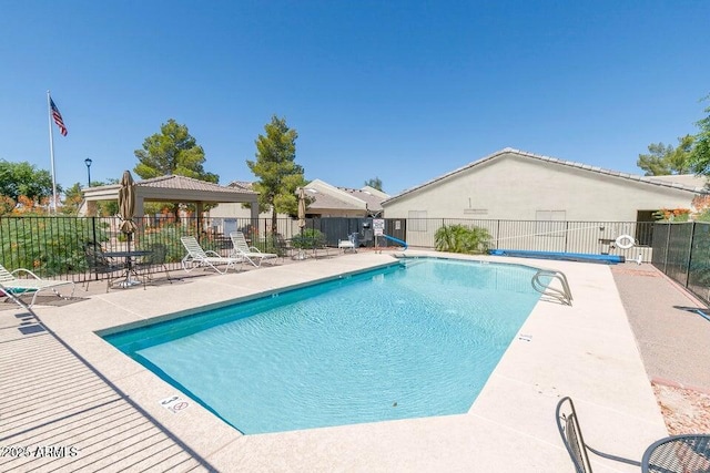 community pool featuring fence, a patio, and a gazebo