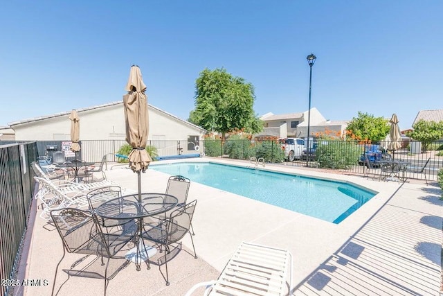 community pool with fence and a patio
