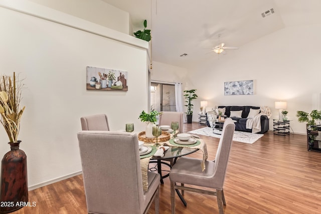 dining room featuring wood finished floors, a ceiling fan, and vaulted ceiling