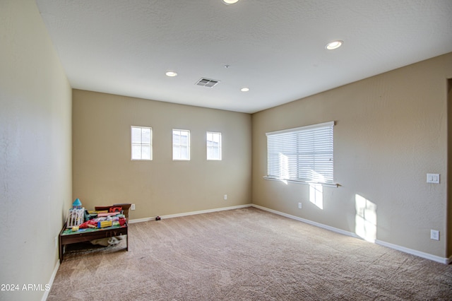 recreation room with light colored carpet