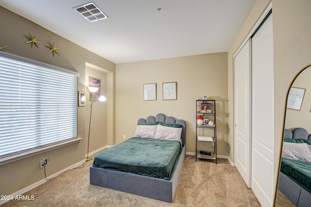 bedroom featuring light carpet and a closet