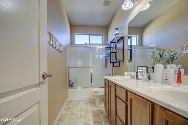 full bathroom with vanity, toilet, and enclosed tub / shower combo