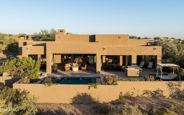 9894 E Miramonte Dr, Scottsdale, AZ 85262 - back of house featuring outdoor lounge area, stucco siding, a patio area, and an outdoor pool