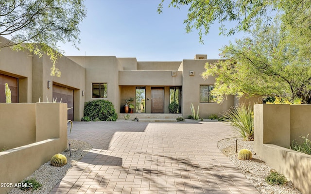 9894 E Miramonte Dr, Scottsdale, AZ 85262 - pueblo-style house featuring a garage, stucco siding, and driveway