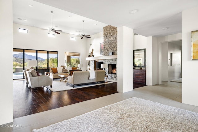 9894 E Miramonte Dr, Scottsdale, AZ 85262 - tiled living room with ceiling fan, a fireplace, a mountain view, recessed lighting, and a towering ceiling