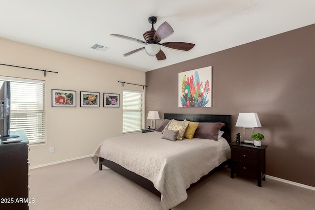 carpeted bedroom with ceiling fan and multiple windows