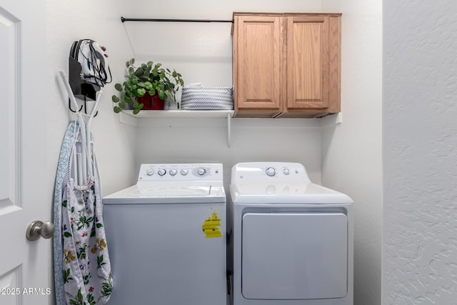 washroom with washer and clothes dryer and cabinets