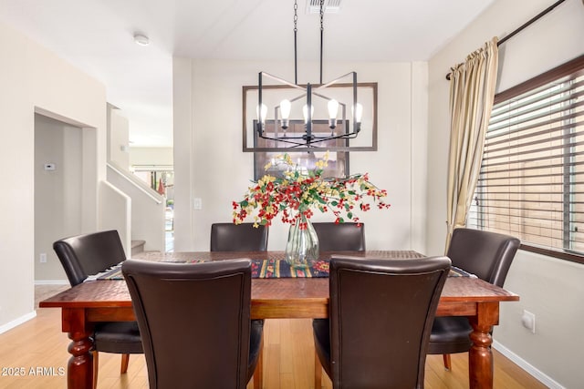 dining space featuring a wealth of natural light, a chandelier, and light hardwood / wood-style flooring