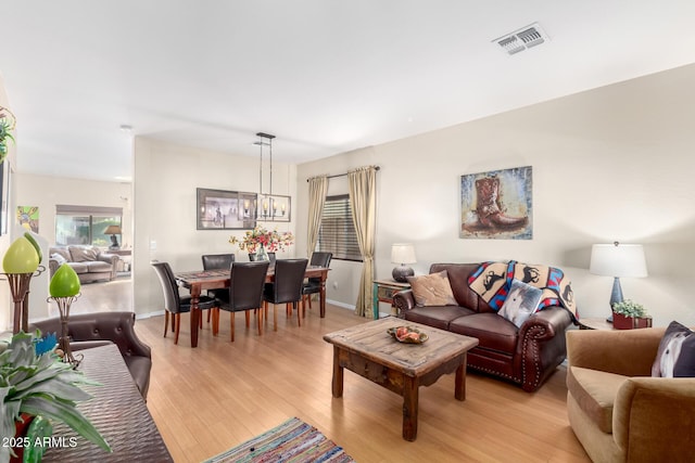 living room featuring a notable chandelier and light hardwood / wood-style floors