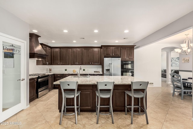 26719 S 195th St, Queen Creek, AZ 85142 - kitchen with custom exhaust hood, fridge with ice dispenser, arched walkways, stainless steel gas stove, and a sink