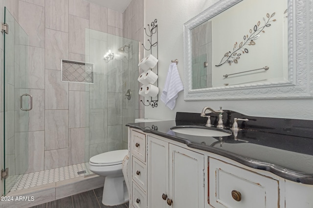 bathroom featuring an enclosed shower, vanity, and toilet