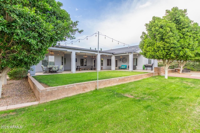 rear view of house featuring a yard, a patio, and ceiling fan