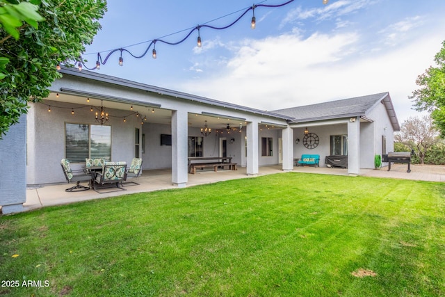 back of property with a patio area and a yard