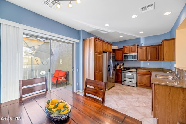 3932 E Melinda Dr, Phoenix, AZ 85050 - kitchen with a sink, appliances with stainless steel finishes, visible vents, stone counters, and brown cabinetry