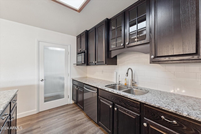 kitchen featuring dishwasher, backsplash, sink, light stone countertops, and light hardwood / wood-style floors