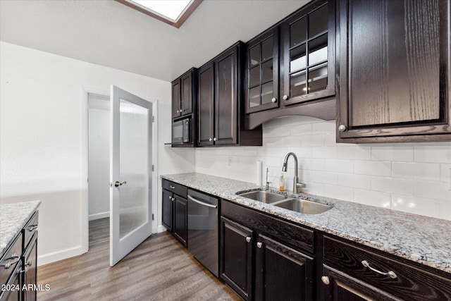 kitchen with dishwasher, sink, decorative backsplash, light wood-type flooring, and light stone counters