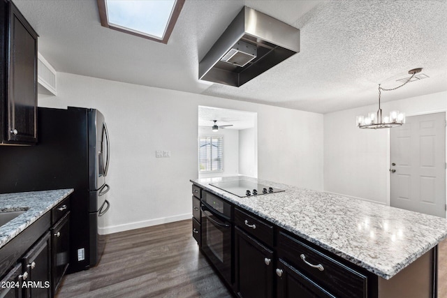 kitchen featuring ceiling fan with notable chandelier, dark wood-type flooring, exhaust hood, black appliances, and a center island