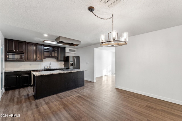 kitchen featuring appliances with stainless steel finishes, dark hardwood / wood-style flooring, sink, a center island, and hanging light fixtures