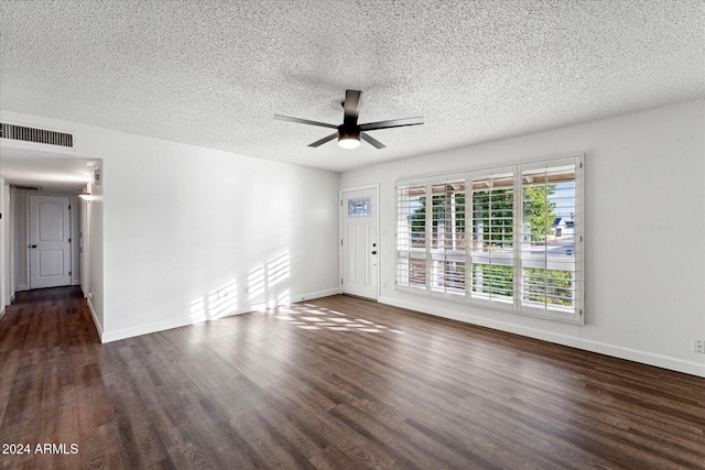 empty room featuring ceiling fan, dark wood-type flooring, and a textured ceiling