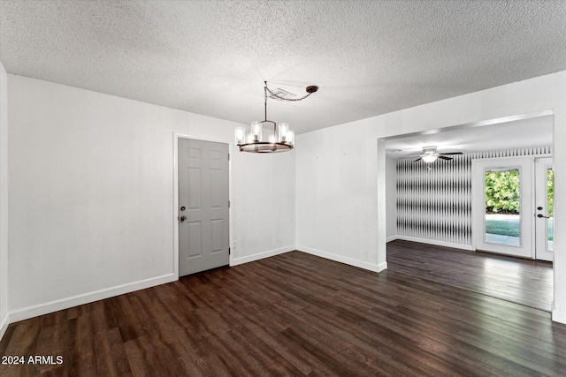 unfurnished dining area featuring dark hardwood / wood-style floors, a textured ceiling, and ceiling fan with notable chandelier