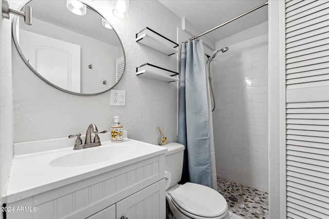 bathroom with a shower with shower curtain, a textured ceiling, vanity, and toilet