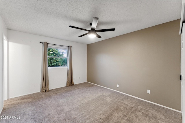 carpeted spare room featuring a textured ceiling and ceiling fan