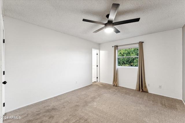 carpeted spare room with a textured ceiling and ceiling fan