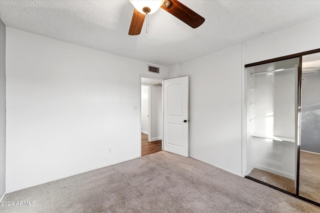 unfurnished bedroom featuring carpet flooring, ceiling fan, a textured ceiling, and a closet