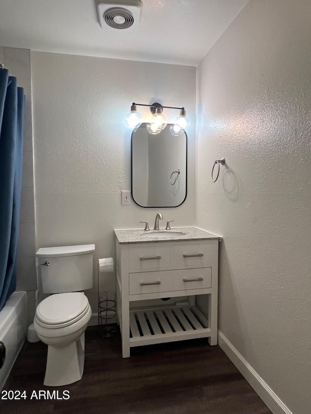 full bathroom featuring hardwood / wood-style floors, vanity, toilet, and shower / bath combo with shower curtain