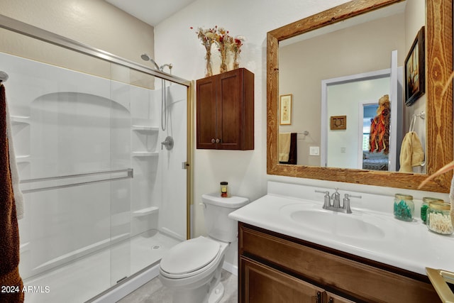 bathroom with walk in shower, vanity, and toilet