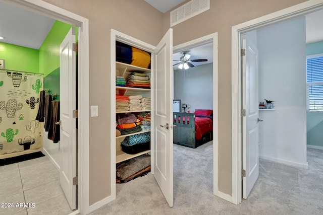 bathroom with ceiling fan and tile patterned floors