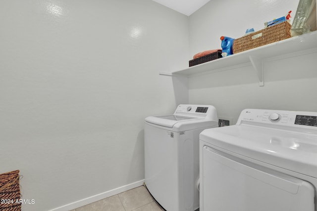 laundry area featuring washer and clothes dryer and light tile patterned floors