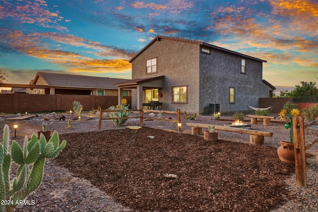 back house at dusk featuring central AC and a patio area